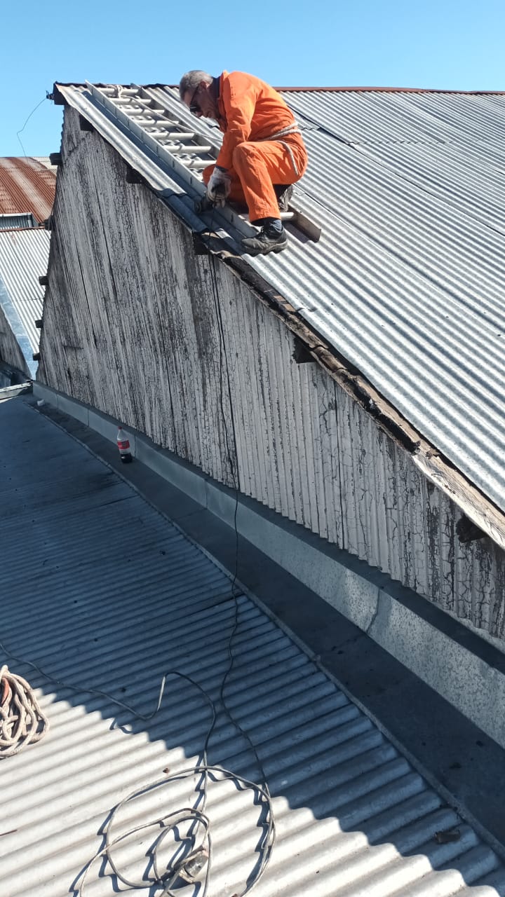 la imagen muestra la reparación del techo de un galpón